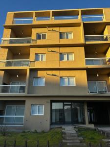 a yellow apartment building with its door open at Monte Hermoso del Este-Punta Tejada in Monte Hermoso