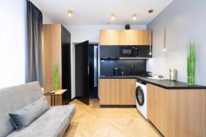 een keuken en een woonkamer met een bank in een kamer bij Rainbow Apartments Old Town in Krakau