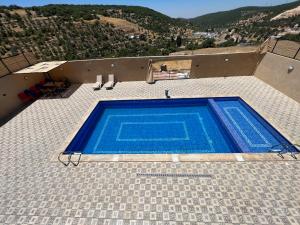 a swimming pool on the side of a house at Gernath farm in Ajloun