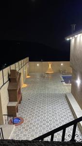 a large tiled patio with a pool at night at Gernath farm in Ajloun