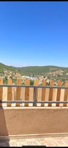a row of wooden chairs sitting on top of a balcony at Gernath farm in Ajloun