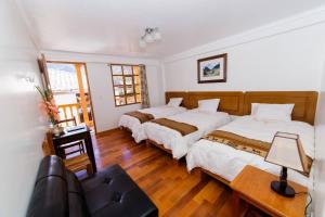 1 dormitorio con 2 camas y sofá en Casablanca lodge, en Ollantaytambo