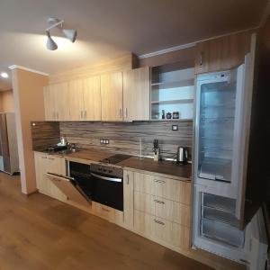 a kitchen with wooden cabinets and a stove top oven at VIP apartmens Suvorov 1 in Bansko