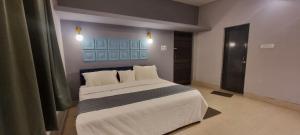 a bedroom with a large bed with white sheets and pillows at HOTEL NEATFLIX & CHILL 2 in Bhubaneshwar