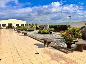 a courtyard with benches and potted plants in a building at Tomas Morato Quezon City - Residences in Manila