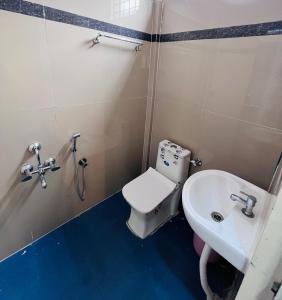 La salle de bains est pourvue de toilettes et d'un lavabo. dans l'établissement RR Stayinn, à Bangalore