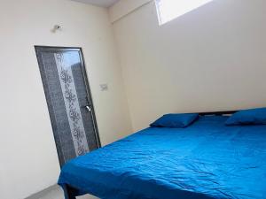 - une chambre avec un lit bleu et une porte dans l'établissement RR Stayinn, à Bangalore