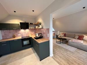 a kitchen and living room with a couch in a room at Ferienwohnung Frau Rogge in Bad Zwischenahn