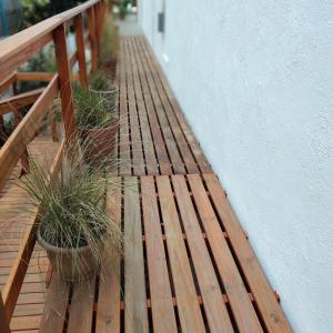 a wooden deck with potted plants on it at Acacia in Pinamar