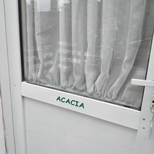 ein Fenster mit dem Wort Acacia darauf in der Unterkunft Acacia in Pinamar
