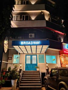 a building with a blue door and stairs in front at Hotel Broadway Udaipur in Udaipur