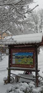 a sign with snow on top of it at Gasthof Alte Schmiede G*** Lückendorf in Luftkurort Lückendorf