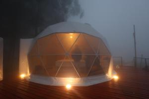 コダイカナルにあるKanal Glamp Kodaikanal Luxuriesの霧の中のデッキに座るテント
