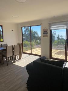 uma sala de estar com um sofá, uma mesa e cadeiras em Cabaña Viaducto Vista al Mar, Curanipe em Pelluhue