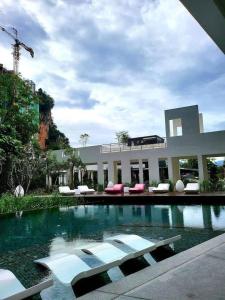 a swimming pool with lounge chairs in front of a building at IPOH TAMBUN THE Cove your ultimate relaxing Getaway666 in Ipoh