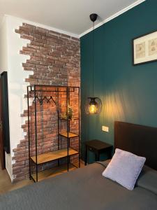 Un dormitorio con una pared de ladrillo y una cama en Hotel Art, en Varna