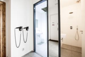 a glass shower door in a bathroom with a sink at Sophie's Hostel in Prague