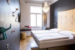 a bedroom with a bed and a window and a chandelier at Sophie's Hostel in Prague