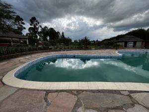 a swimming pool in a yard with a cloudy sky at Lulunga Eco Lounge and Farm in Narok