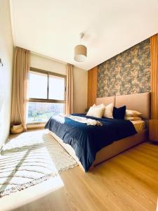 a bedroom with a large bed and a window at Luxueux Appartement Prestigia in Marrakech