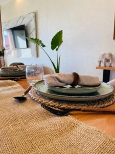 Luxueux Appartement Prestigia في مراكش: طاولة مع طبقين وكأس النبيذ