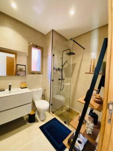 uma casa de banho com um chuveiro, um WC e um lavatório. em Luxueux Appartement Prestigia em Marraquexe