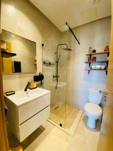 uma casa de banho com um WC, um lavatório e um chuveiro em Luxueux Appartement Prestigia em Marraquexe