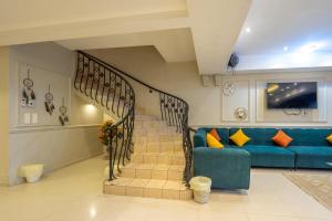 ein Wohnzimmer mit einer Treppe und einem blauen Sofa in der Unterkunft فيلا على البحر درة العروس in Durrat Al-Arus