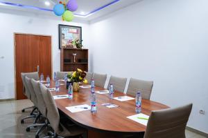 una sala conferenze con tavolo, sedie e bottiglie d'acqua di EKA ELITE HOTEL a Lomé