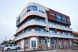 een gebouw waar een auto voor geparkeerd staat bij EKA ELITE HOTEL in Lomé