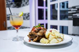 a plate of food and a drink on a table at EKA ELITE HOTEL in Lomé
