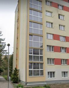 um edifício alto com muitas janelas do lado em Veludo Apartments Centrum free parking em Banská Bystrica