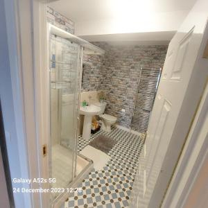 a bathroom with a toilet and a glass shower at Mews Apartment Main St, Carrigart, F92HC04 in Carrigart