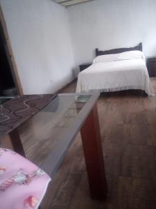 a bedroom with a bed and a glass table at Arriba y La escondida in Villa Gesell