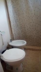 a bathroom with a white toilet and a sink at Arriba y La escondida in Villa Gesell
