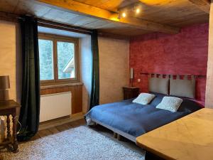 a bedroom with a blue bed and a window at La Combe de Moulin in Peisey-Nancroix