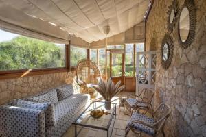 a living room with a couch and chairs and windows at La Sultana Oualidia in Oualidia