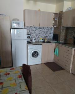 cocina con nevera blanca y lavavajillas en Апартамент Анастасия Аполон 6, en Ravda