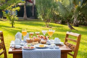 a bird standing on a table with food and drinks at Pousada Déllis in Visconde De Maua