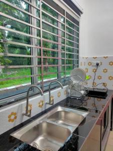 une cuisine avec un évier et une fenêtre dans l'établissement Homestay Fayyadh Teluk Intan 3Room2Bath, à Teluk Intan