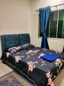 a bedroom with a bed and a window with blue curtains at Homestay Fayyadh Teluk Intan 3Room2Bath in Teluk Intan
