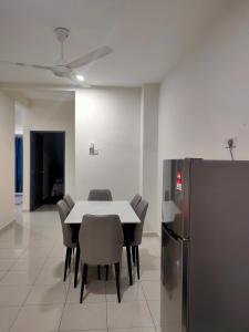 ein Esszimmer mit einem Tisch und Stühlen sowie einem Kühlschrank in der Unterkunft Homestay Fayyadh Teluk Intan 3Room2Bath in Teluk Intan