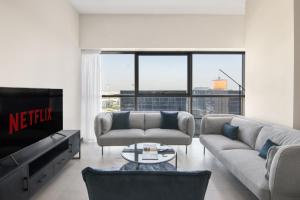 a living room with a couch and a tv at Sophisticated & Classy stay at The Onyx in Dubai