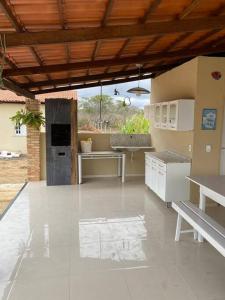eine Küche mit weißen Geräten und einer Holzdecke in der Unterkunft Chácara Moreira in Tianguá