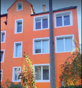 un bâtiment orange avec des fenêtres blanches et un poteau dans l'établissement Angel, à Altenburg