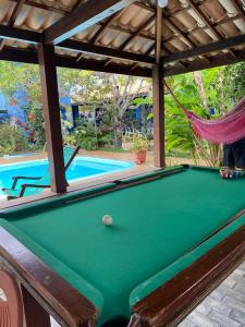 a pool table in front of a swimming pool at Cantinho dos Machados in Camaçari