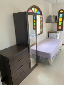 1 dormitorio con litera y vestidor con espejo en Cantinho dos Machados en Camaçari