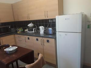 a kitchen with a white refrigerator and a table at Robs Place, Liverpool in Liverpool