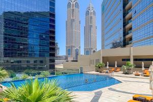 a pool in the middle of a city with tall buildings at Sophisticated & Classy stay at The Onyx in Dubai