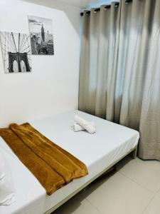 a bedroom with a bed with a blanket on it at Ever Stays at Light Residences 1BR in Manila